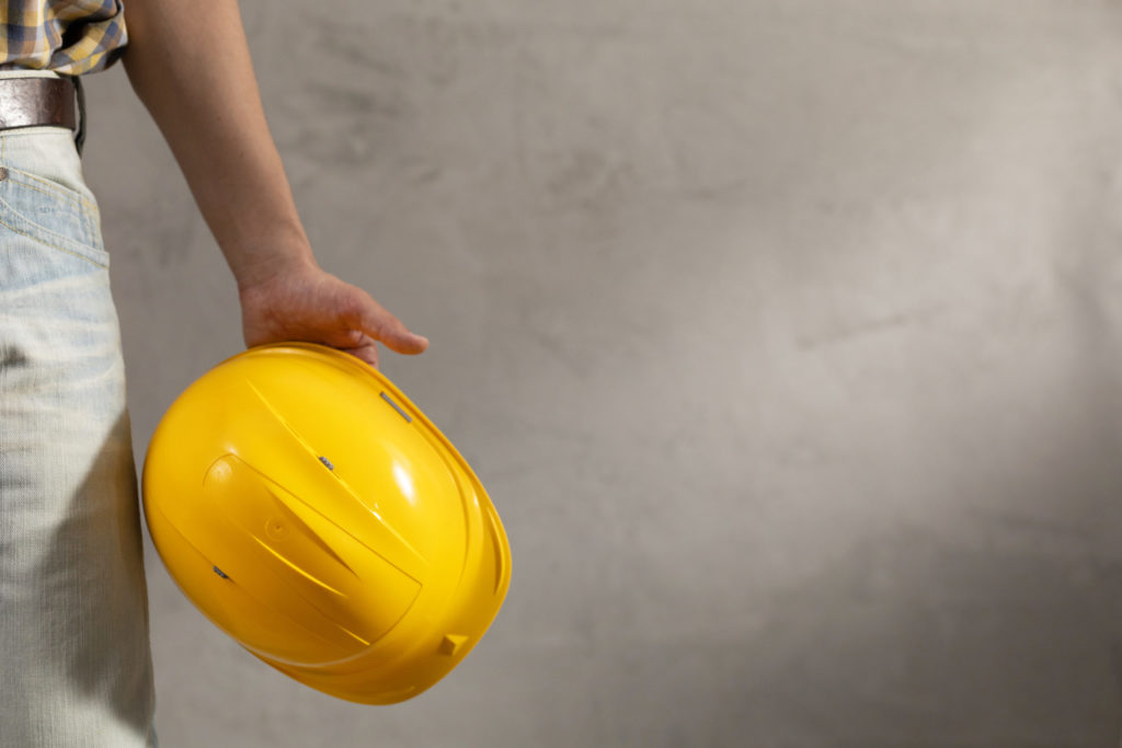 Worker man holding construction helmet