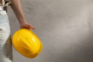 Worker man holding construction helmet