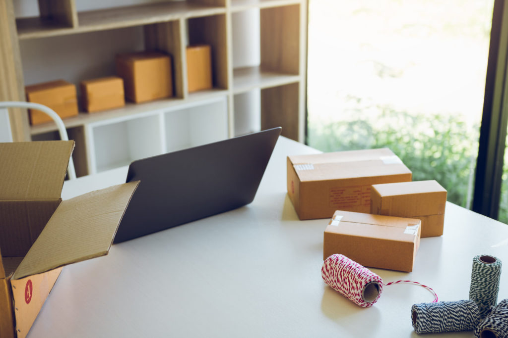 a table with a laptop and a pile of boxes on it