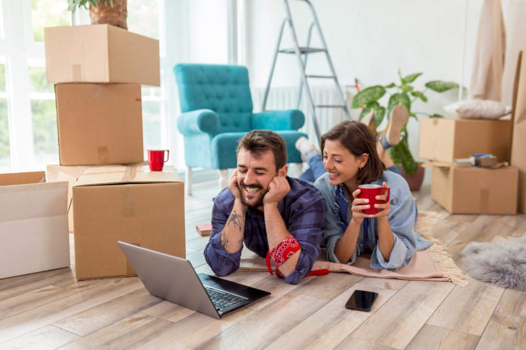 Couple searching the Web for apartment redecoration ideas while moving in together