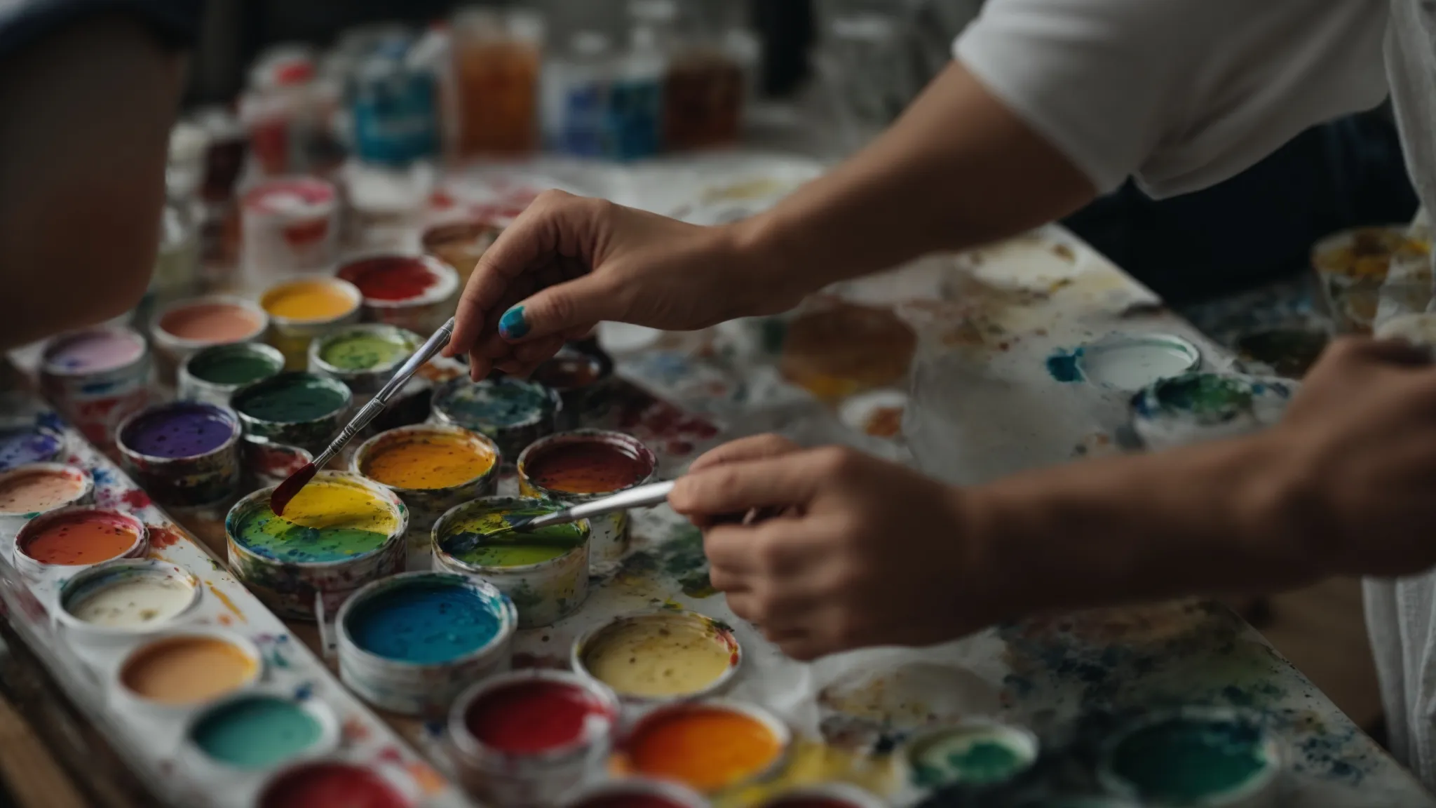 a painter mixes several vibrant paints on a palette, blending new shades while keeping some original colors untouched.
